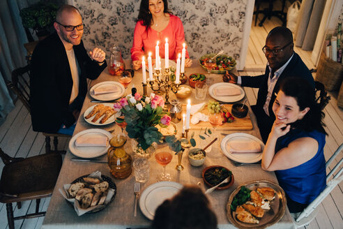 Reife männliche und weibliche Freunde genießen das Abendessen auf einer Party - MASF09049