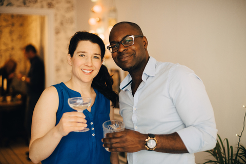Porträt von multiethnischen Freunden, die auf einer Party zu Hause Getränke genießen, lizenzfreies Stockfoto
