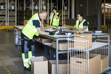 Multiethnische Arbeiter verpacken Waren im Auslieferungslager - MASF09125