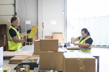 Mitarbeiter verpacken Waren auf dem Schreibtisch eines Vertriebslagers - MASF09133