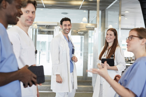 Smiling multi-ethnic healthcare team discussing at lobby in hospital stock photo