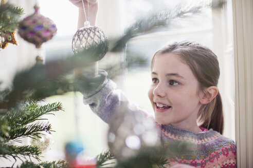 Mädchen schmückt, hängt Ornament an Weihnachtsbaum - HOXF03782