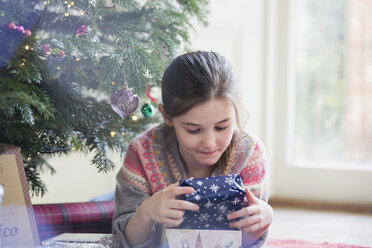 Neugieriges Mädchen hält Weihnachtsgeschenk - HOXF03786