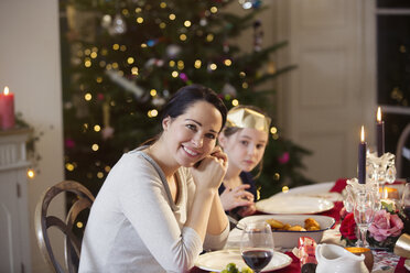 Portrait lächelnde Mutter und Tochter beim Weihnachtsessen bei Kerzenschein - HOXF03806