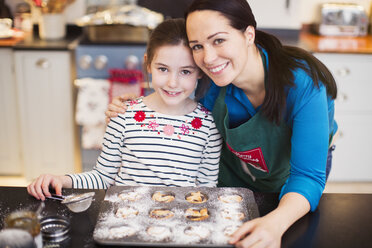 Portrait lächelnde Mutter und Tochter beim Backen in der Küche - HOXF03851