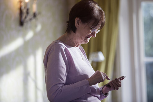 Ältere Frau benutzt ein Smartphone - HOXF03874