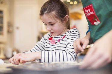 Focused girl baking, using cookie cutter - HOXF03881