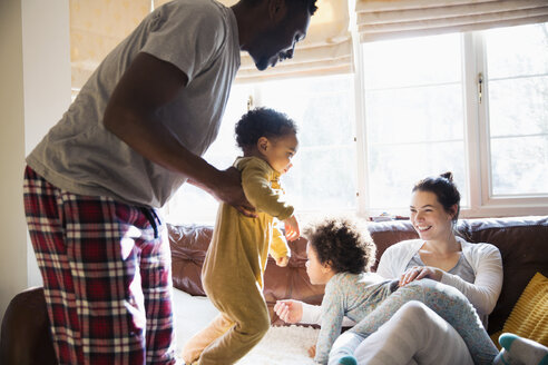 Verspielte multiethnische Familie im Pyjama im Wohnzimmer - HOXF03931