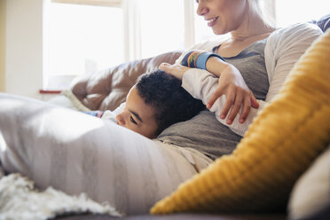 Zärtliche Mutter und Sohn kuscheln auf dem Sofa - HOXF03937