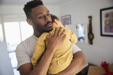 Zärtlicher Vater hält müden Babysohn - HOXF03939