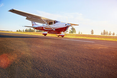 Landung eines Propellerflugzeugs auf einer sonnigen Landebahn - CAIF21754