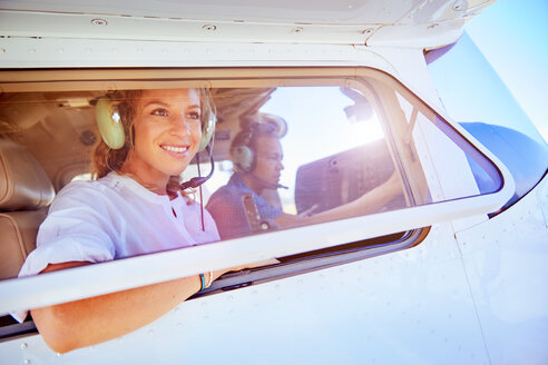 Lächelnde Frau in einem Kleinflugzeug - CAIF21757