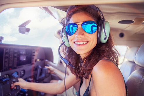 Portrait lächelnd, zuversichtlich junge Frau fliegt Flugzeug - CAIF21765