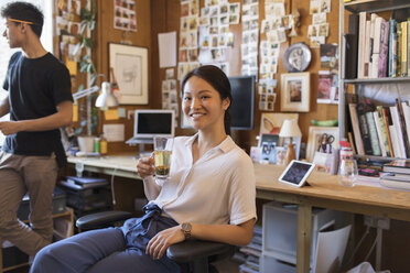 Porträt einer lächelnden, selbstbewussten, kreativen Geschäftsfrau, die im Büro Tee trinkt - CAIF21772