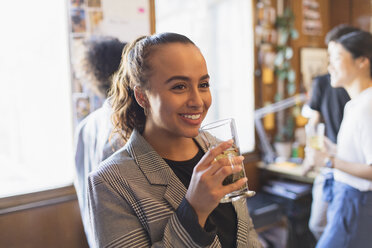 Porträt einer lächelnden Geschäftsfrau beim Teetrinken im Büro - CAIF21791