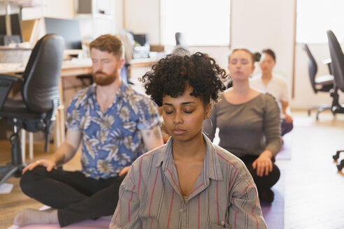 Gelassene, kreative Geschäftsleute beim Meditieren im Büro - CAIF21829