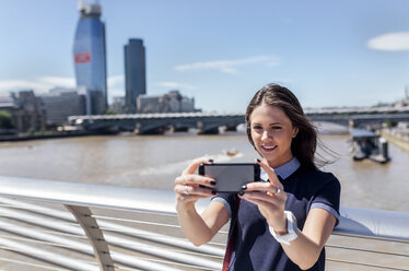 UK, London, Frau macht ein Selfie auf der Millennium Bridge - MGOF03781