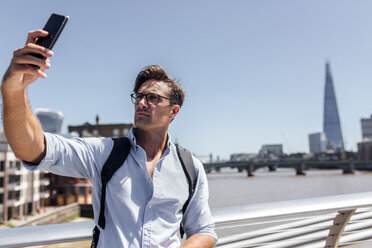 UK, London, man taking a selfie on Millennium Bridge - MGOF03785