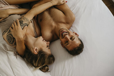 Romantisches glückliches junges Paar im Bett liegend - LHPF00032