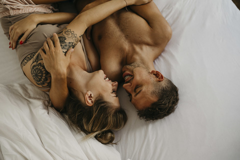 Romantisches glückliches junges Paar im Bett liegend, lizenzfreies Stockfoto