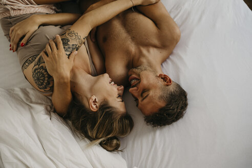 Romantisches glückliches junges Paar im Bett liegend - LHPF00033