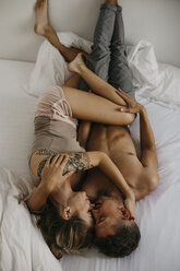 Romantic young couple lying in bed - LHPF00035