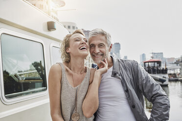 Happy older man and young woman on jetty next to yacht - RORF01554