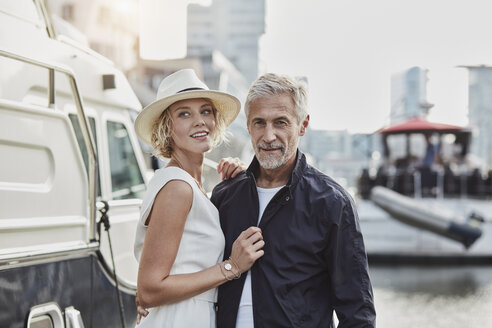 Older man and young woman at a marina next to a yacht - RORF01562