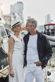 Older man and young woman at a marina next to a yacht - RORF01564