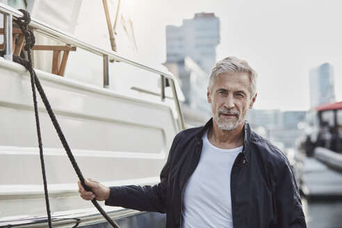 Selbstbewusster reifer Mann in einem Yachthafen neben einer Jacht - RORF01565