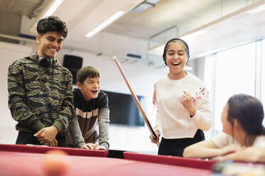 Fröhliche Teenager spielen Pool im Gemeindezentrum - CAIF21835