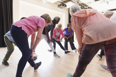 Aktive Senioren strecken ihre Beine im Sportkurs - CAIF21875