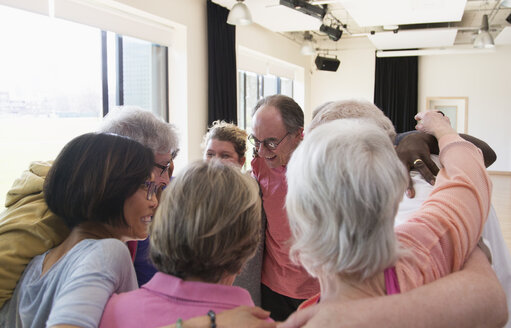 Aktive Senioren umarmen sich im Kreis - CAIF21901