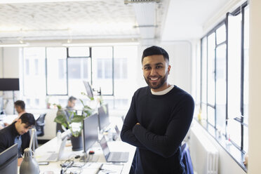 Portrait smiling, confident businessman in open plan office - CAIF21939