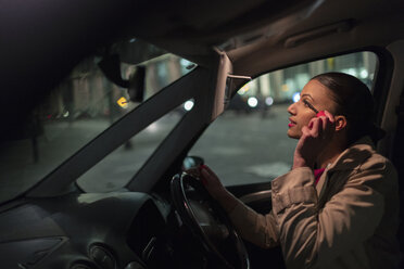 Geschäftsfrau trägt nachts im Auto Wimperntusche auf - CAIF21962