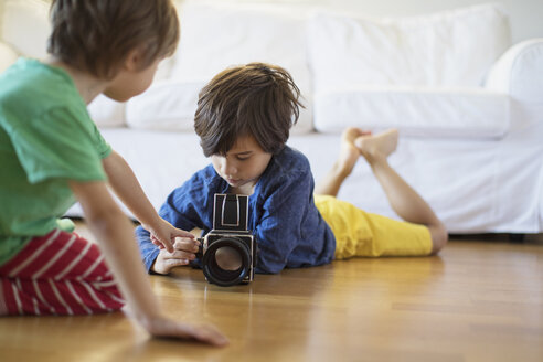 Zwei Brüder erkunden zu Hause eine altmodische Filmkamera - AZOF00019