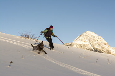 Eine Frau und ihr Hund beim Skifahren im San Juan National Forest, Durango, Colorado. - AURF04117