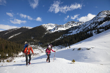 Ein junges, aktives Paar beim Wandern im Schnee. - AURF04127