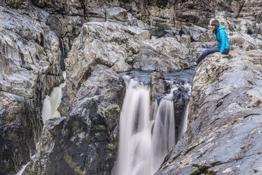 Eine Frau blickt auf einen Wasserfall am Taylor River auf Vancouver Island hinunter. - AURF04148