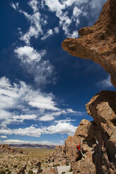 Ein junger Mann spielt auf den Felsen in der Atacama-Wüste. Der Salar de Uyuni ist die größte Salzfläche der Welt und beherbergt eines der größten Lithiumvorkommen der Welt. Die Gemeinden in der Umgebung dieser Region könnten von der Erschließung und dem Abbau stark profitieren oder darunter leiden. - AURF04190