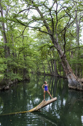 Eine junge Frau genießt ein ruhiges Schwimmloch, das Blue Hole, in der Nähe von Wimberley, Texas. - AURF04192