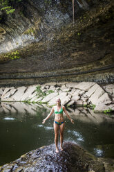 Eine junge Frau vergnügt sich an einem heißen Tag im Hamilton Pool in der Nähe von Wimberley, Texas. - AURF04194