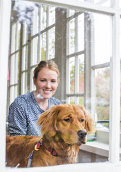 A young dog owner enjoys time with her dog in their home. - AURF04196