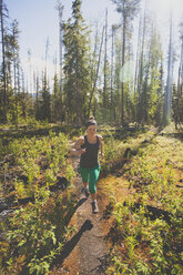 Eine junge, fitte Frau beim Trailrunning im Bowron Lake Provincial Park. - AURF04206