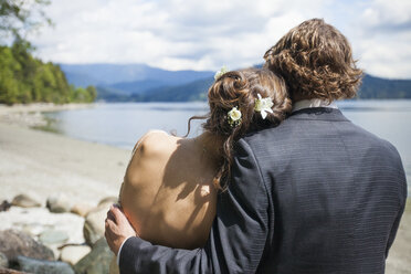 A young couple embrace each other while at the looking out at Burrard Intlet, Vancouver B.C. - AURF04214