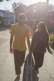 Ein junger Mann und eine Frau gehen durch eine Straße in der Nachbarschaft. - AURF04276