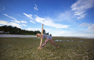 Schönes Mädchen am Strand beim Yoga - AURF04287