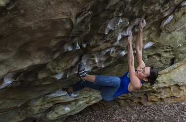 Sportliche Frau versucht sich am überhängenden Felsen - AURF04320