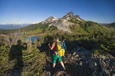 Ein Fotograf fotografiert eine junge Frau beim Wandern auf dem Panorama Ridge Trail im Garibaldi Provincial Park, British Columbia, Kanada. - AURF04324