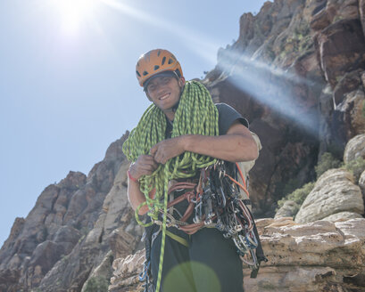 Ein Kletterer wickelt ein Seil auf dem Gipfel eines Klettersteigs in Red Rocks, Nevada, auf. - AURF04392